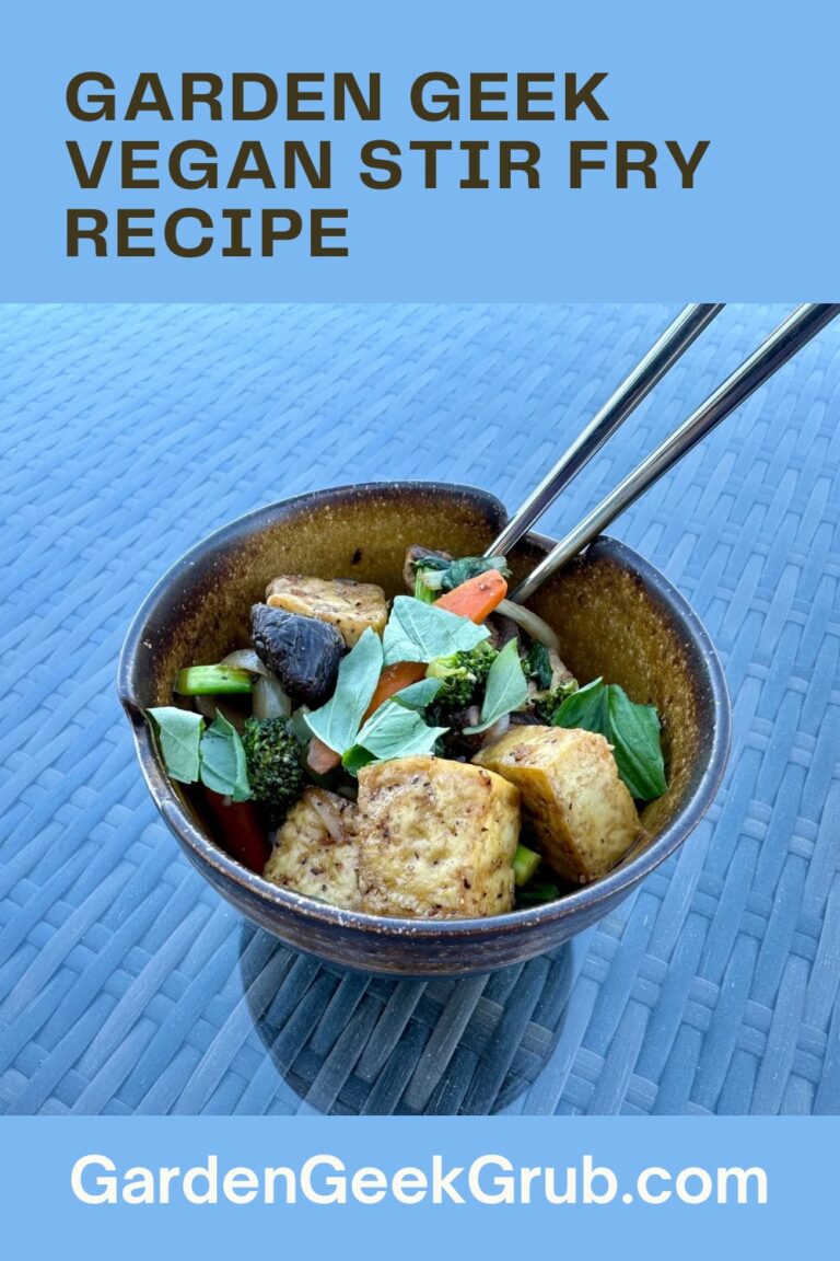 A bowl of vegan stir fry with air-fried tofu, shiitake mushrooms, broccoli, bell peppers, and fresh basil, captured on a woven glass table with chopsticks resting on the bowl’s rim.