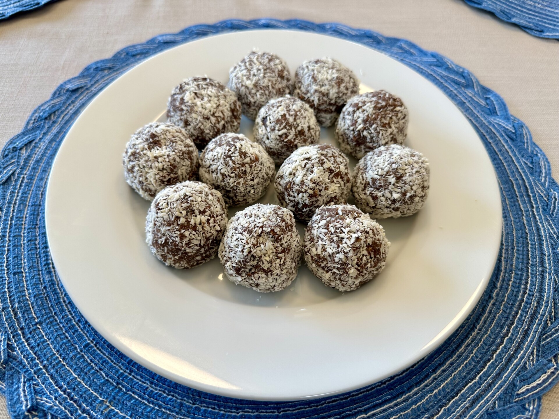 A batch of homemade Plant-Based Protein Balls made with Medjool dates, nut butter, rolled oats, and shredded coconut, displayed on a plate for a nutritious and delicious snack.