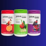 Juice Plus Essentials fruit, vegetable, and berry blend supplements in colorful bottles against a blue background.